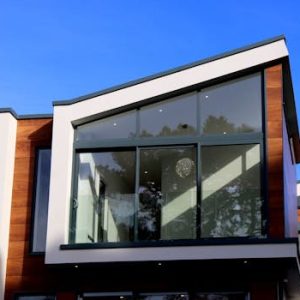 Contemporary house in Poole, UK featuring a sleek design with large glass windows and wood paneling.